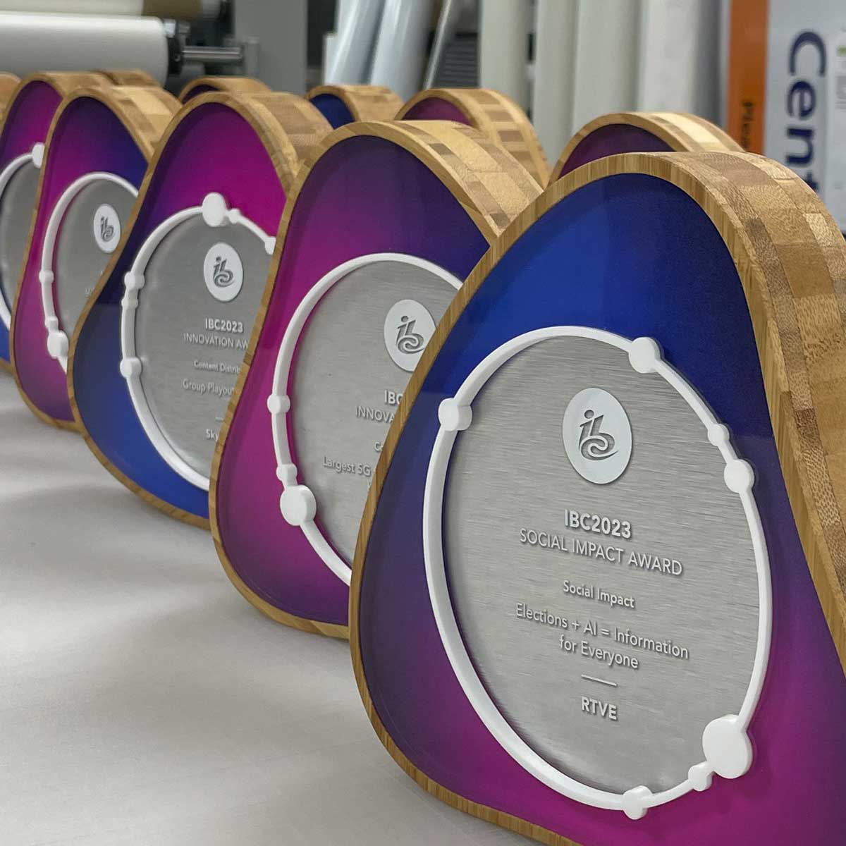 Bespoke IBC 2023 awards with rotating central discs, bamboo outer shell and gradient acrylic detailing – custom sustainable trophies