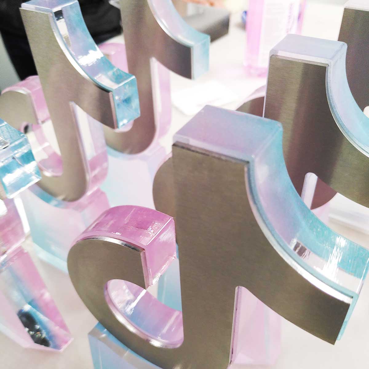 Bespoke TikTok trophies in pink and blue acrylic with brushed aluminium face – custom digital brand awards