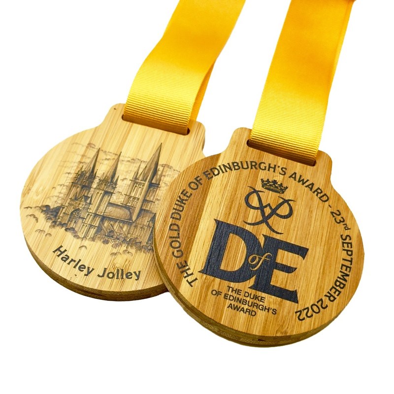 Duke of Edinburgh bamboo medals with yellow ribbons, showing the printed front and personalised engraved reverse