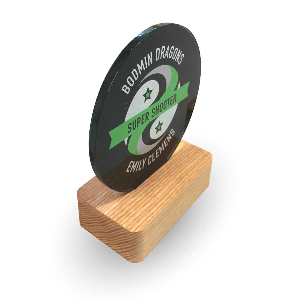 Bodmin Dragons netball award with a circular black face and wooden base