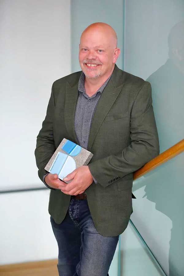 Recipient receiving custom-made concrete award created by More Awards