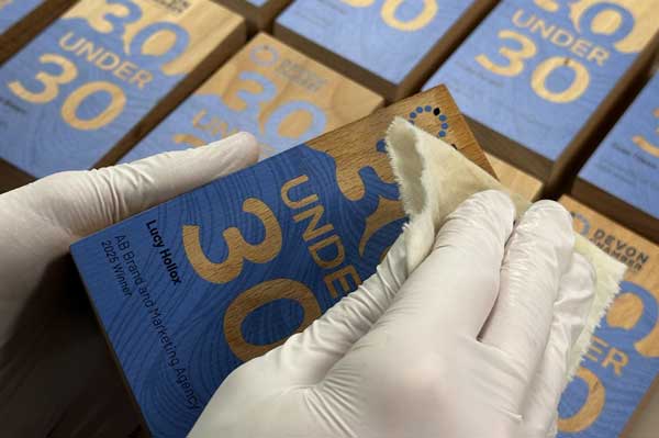 Lowdy wooden block awards with printed designs being prepared – More Awards production