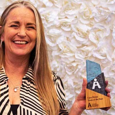 Recipient accepting the Aswen Award made from recycled glass and bamboo during a live ceremony 
