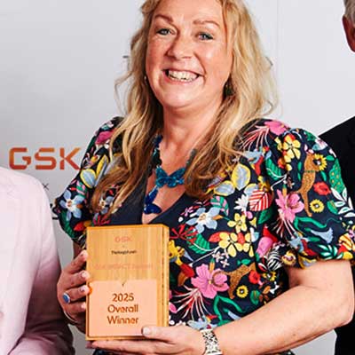 Proud winner holding the Eynda custom wooden block award
