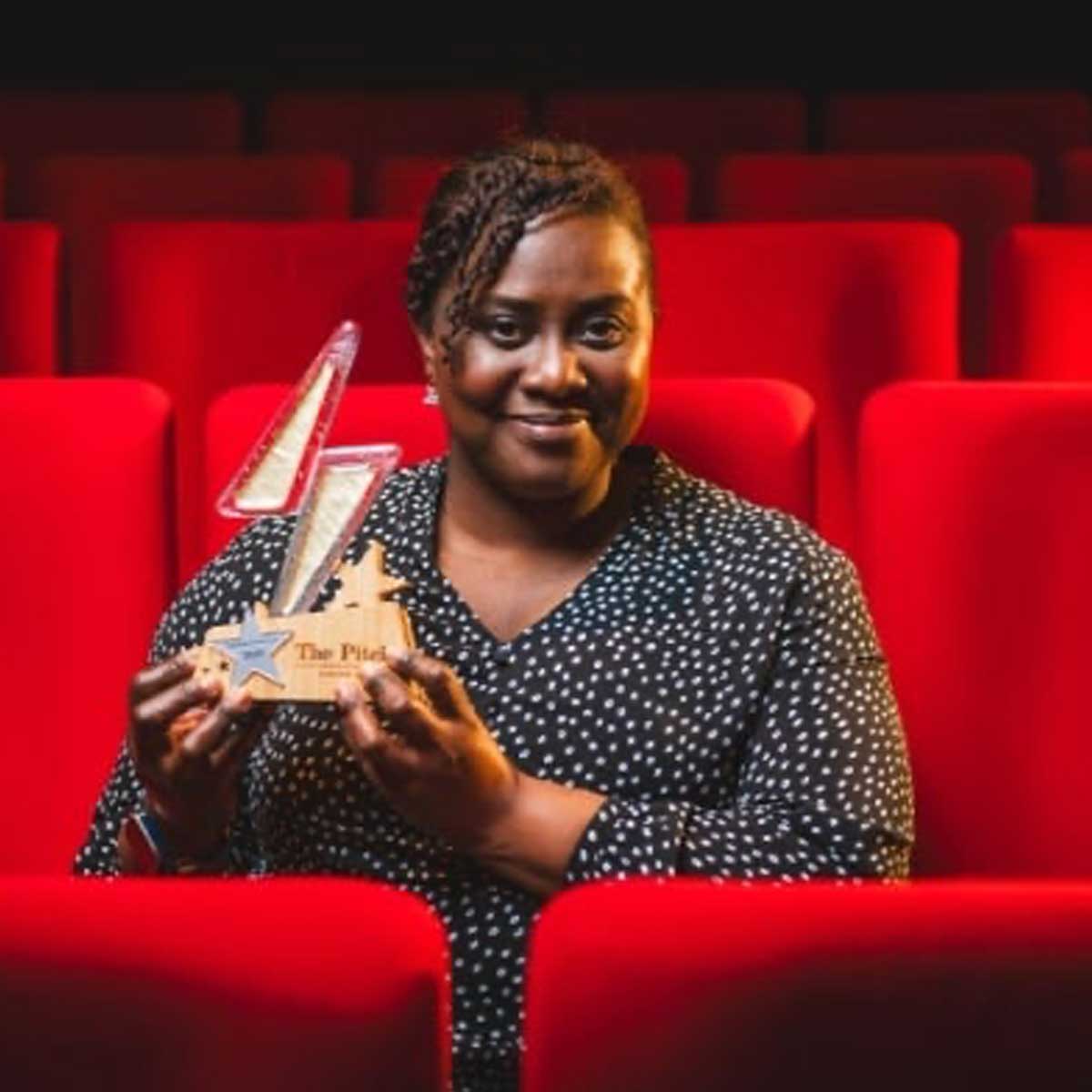 Winner of lightning bolt award made from glass presented in cinema seating area | by More Awards