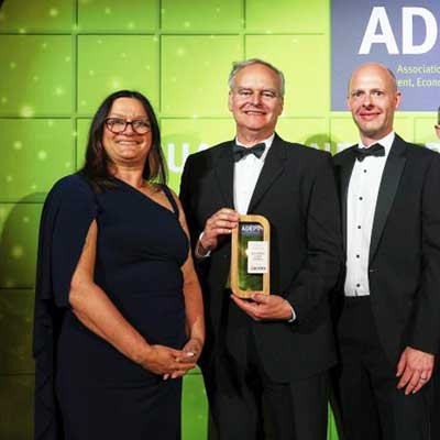 Business leaders receiving bamboo frame trophy