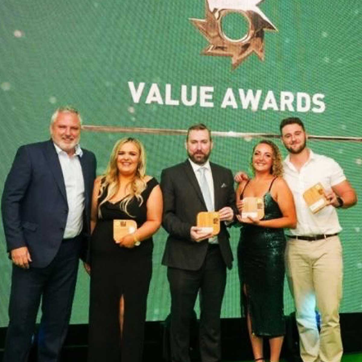Corporate team awarded a Kensa square metal plaque trophy by More Awards during an industry awards gala