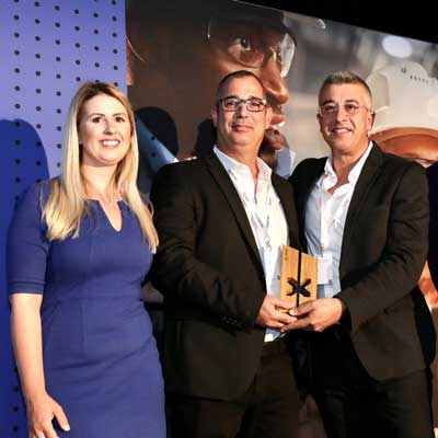 Recipient accepting the Steren Award made from recycled glass and bamboo during a live ceremony